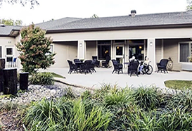 A white building with a patio. Description generated by AI